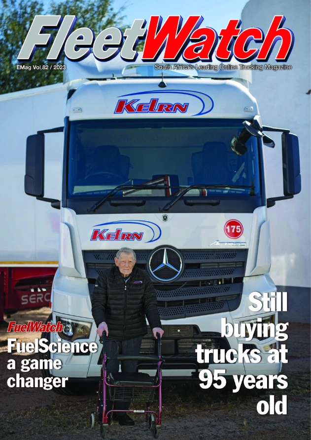 Elderly man with walker in front of a truck.